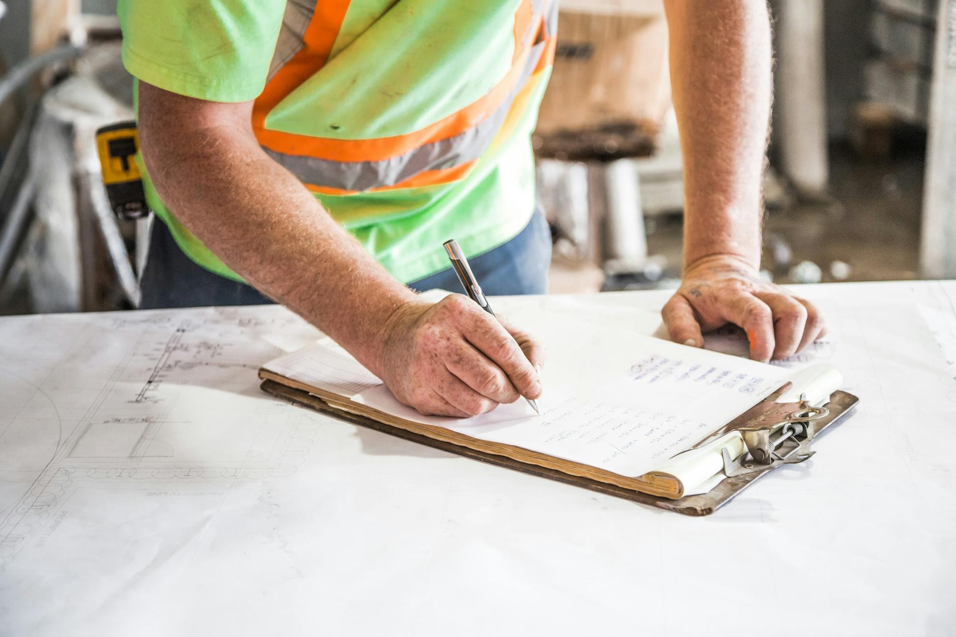 person writing on paper on top of table